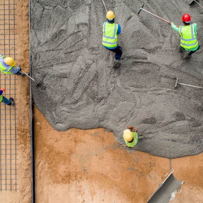 construction-worker-pouring-wet-concret-road-construction-site-sml construction-worker-pouring-wet-concret-road-construction-site-sml